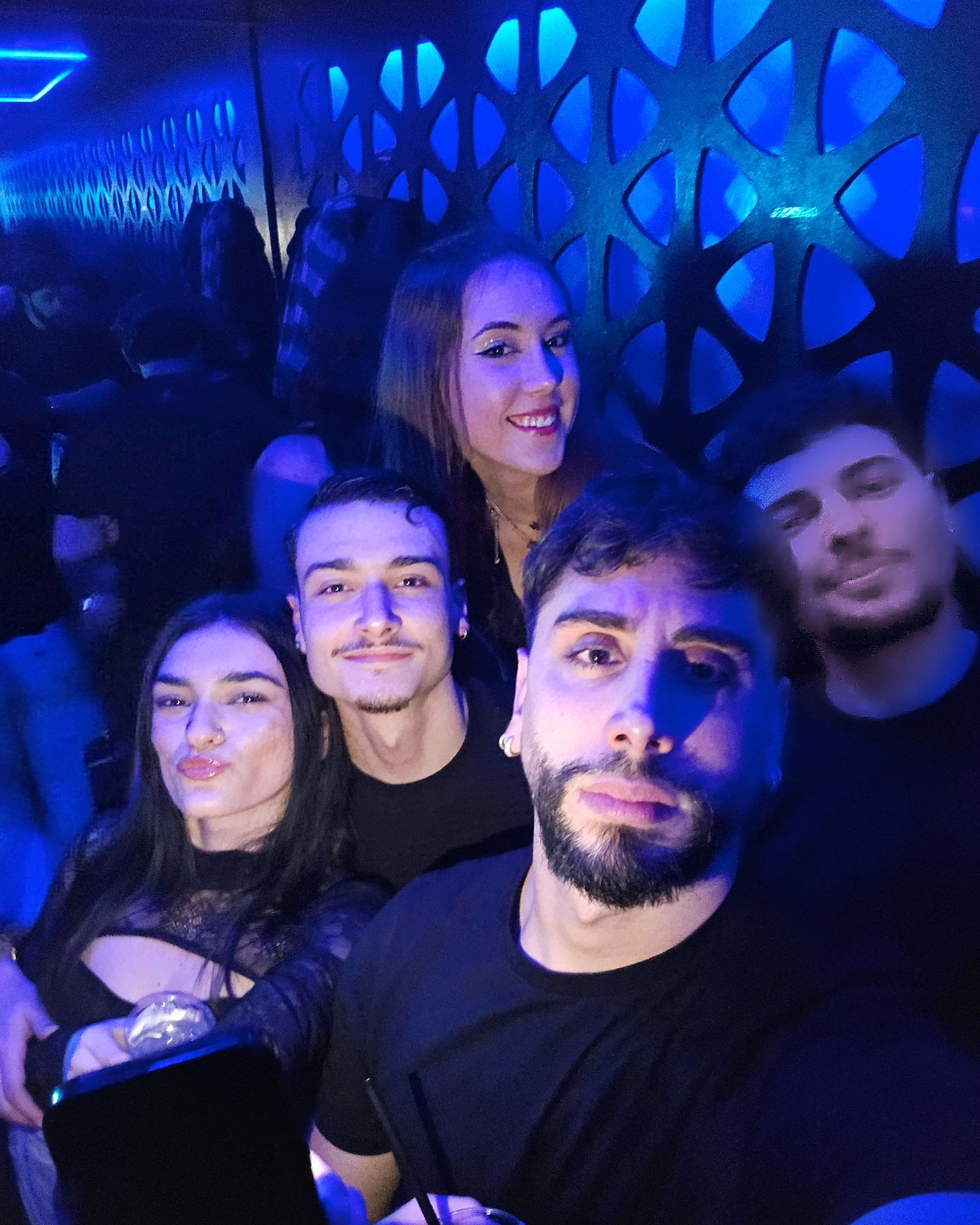 Cinque amici in posa per un selfie in discoteca, sotto le luci blu